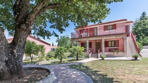 A two-story building with a balcony, stone facade, and a paved pathway leading to the entrance. - Cozy home in Labin with kitchen (Labin)