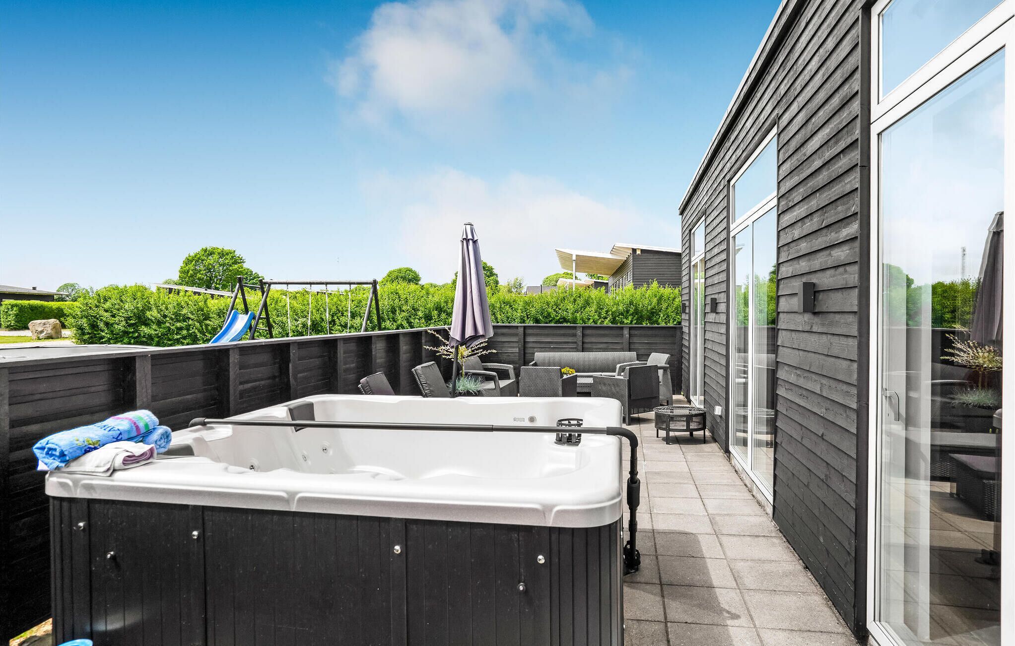Eine Dachterrasse mit Whirlpool, Sitzgelegenheiten im Freien und einer Rutsche.