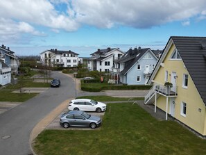 A residential street with houses, a clear sky, and parked cars. - Meeresbrise Fireplace · Patio · 250 m to the beach - Meeresbrise Accommodation (Börgerende-Rethwisch)