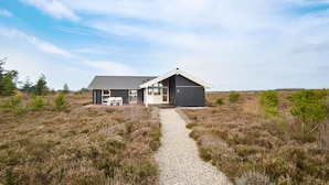 Een modern huis met een grindpad dat naar de ingang leidt.