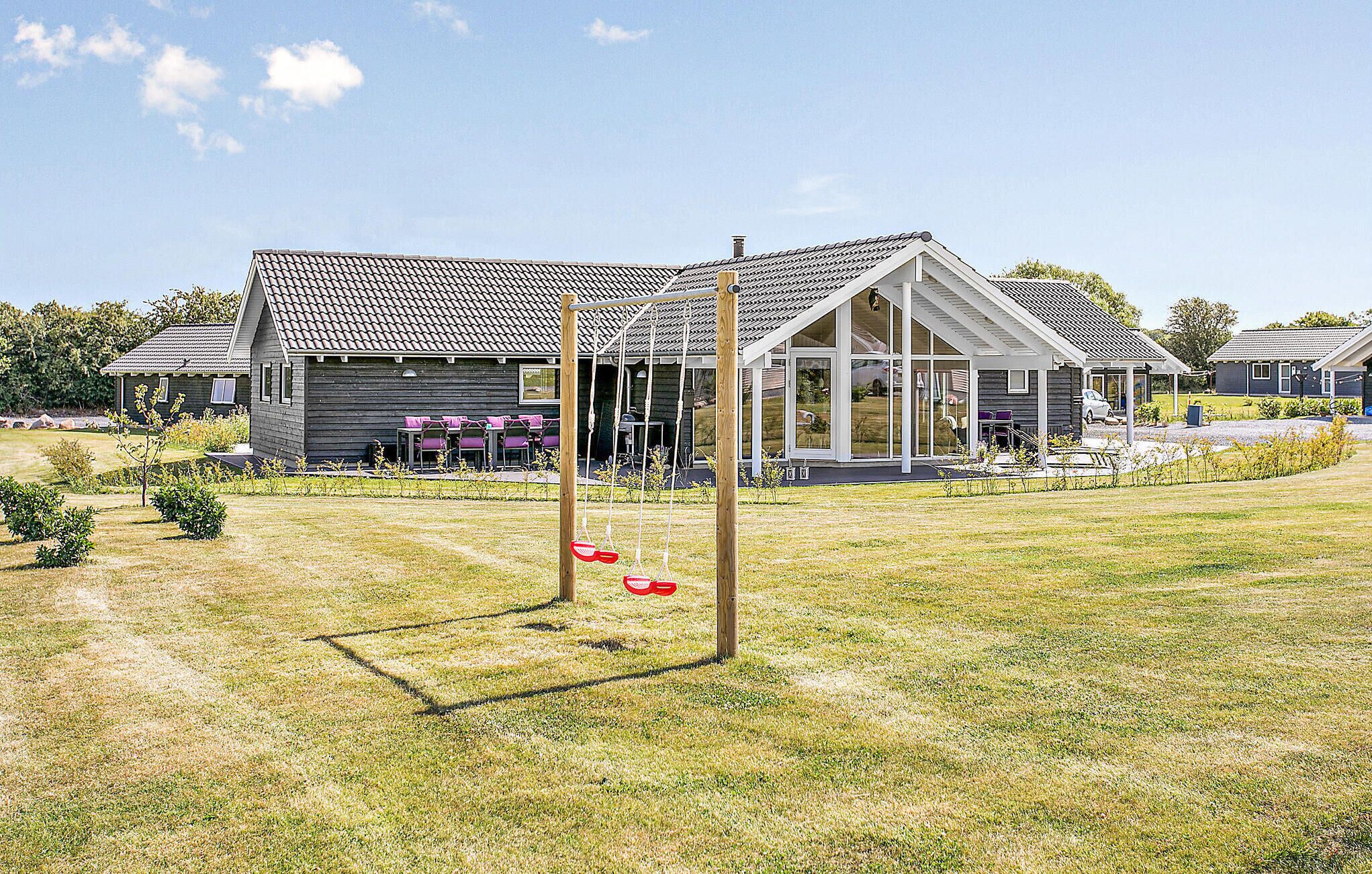 Een woonwijk met een huis, voorzien van een ruime veranda en buitenmeubilair.