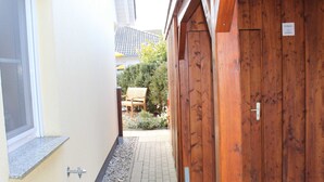 A narrow hallway with a wooden door and a window on the left.