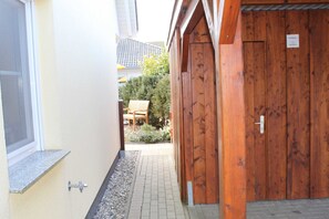 Ein schmaler Flur mit einer Holztür und einem Fenster links.