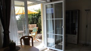 A room with a sliding glass door leading to an outdoor area with a chair and an umbrella.