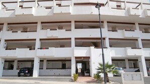 A multi-story building with a flat facade, multiple balconies, and a central entrance. - Amazing apartment in Roldán with swimming pool (Roldán)