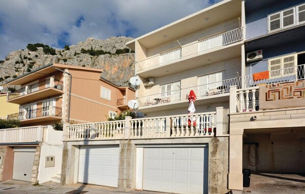 A multi-story residential building with balconies, satellite dishes, and a garage. - Amazing apartment in Omis with WiFi (Omis)