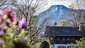 Un bâtiment traditionnel doté d’un toit en pente, d’un balcon et d’une statue devant l’entrée.