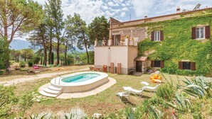 A villa with a swimming pool, outdoor seating, and a lush garden.
