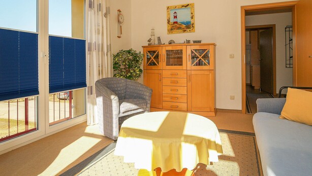 A room with a bed, a chair, a wooden cabinet, and a window with blinds. - Dune garden Whg. Wa47-24 - Wa47-24 (Kühlungsborn)