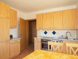 Una cucina compatta con mobili in legno, un piano cottura e un lavandino.