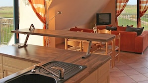 Una cocina compacta con lavamanos integrado y una zona de comedor con mesa y sillas.