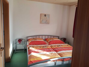 Une chambre à coucher avec un lit, une table de chevet, une lampe et un tableau au mur.