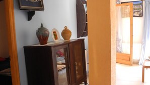Een kamer met een houten kast, een schilderij en een betegelde vloer.