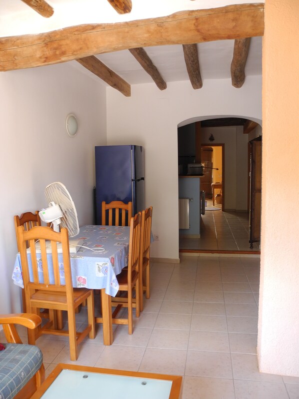 A dining area with a table set for four, wooden chairs, a blue tablecloth, a fan, and a blue refrigerator. - Romantically authentic, lots of space, great views, fiber optics for remote working (Torroja del Priorat)