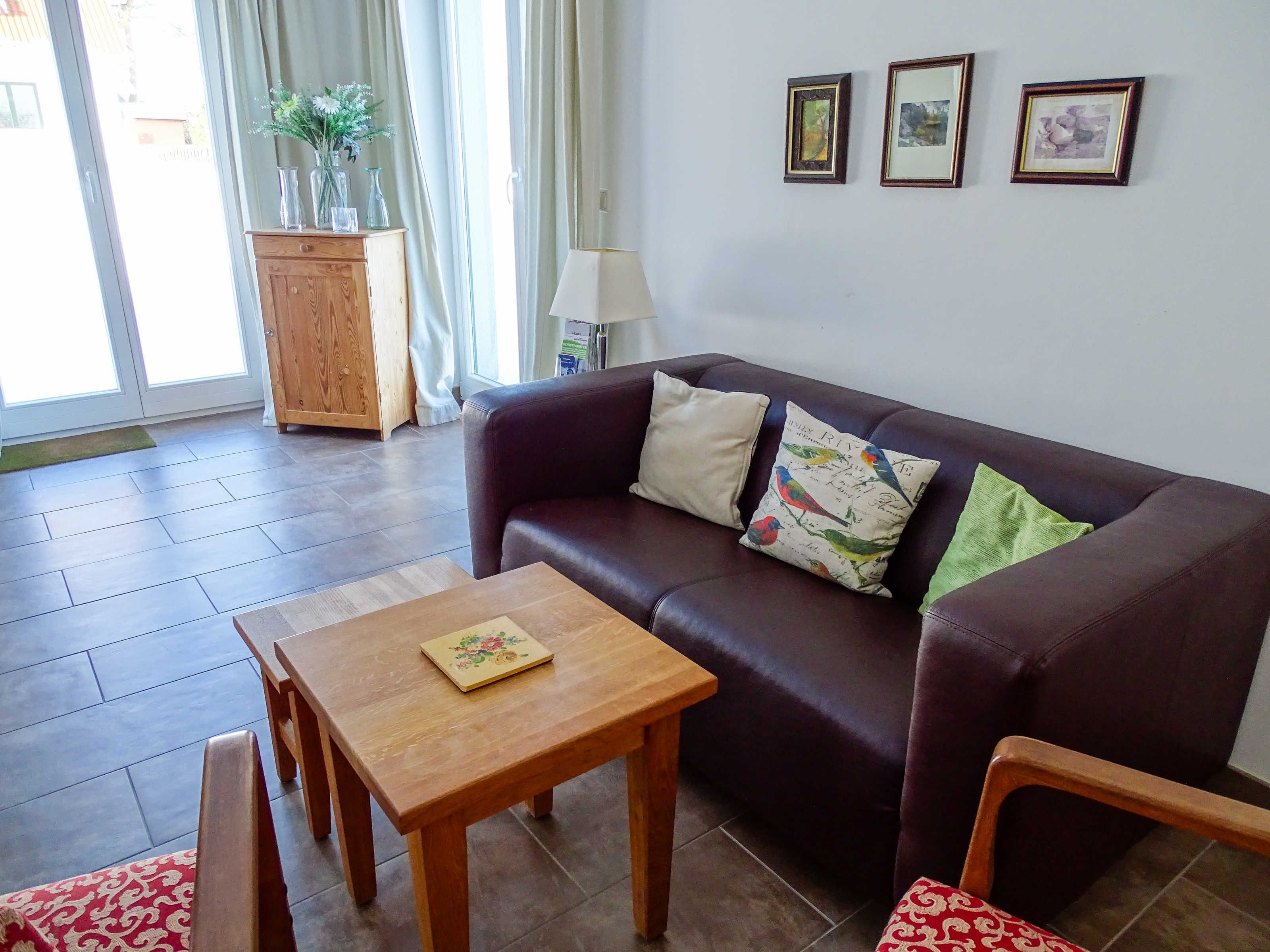 A living room with a sofa, a wooden table, and a cabinet.