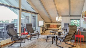 Ein geräumiger Loft mit hohen Decken, großen Fenstern und einer gemütlichen Sitzecke mit modernen Möbeln.