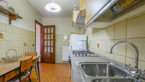 Una cucina compatta con un tavolo da pranzo, un fornello, un lavandino e un frigorifero.