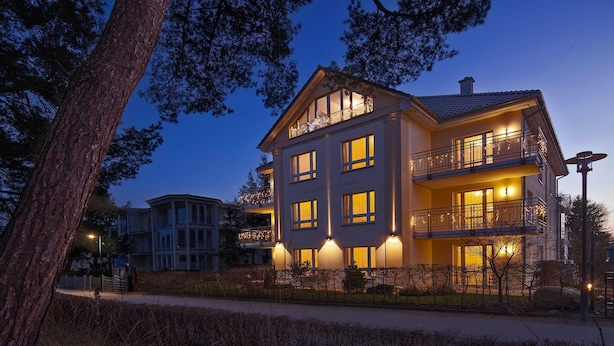 A multi-story hotel with balconies, large windows, and a well-lit facade.