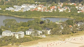 A coastal town with a beach, houses, and a lake.