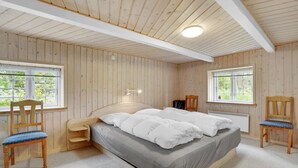 A bedroom with a large bed, two chairs, a desk, and a window. - Stunning home in Ulfborg with sauna (Ulfborg)