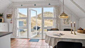 Eine gemütliche Küche mit Essbereich, großen Fenstern und Blick ins Freie.