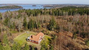 An aerial view of a house surrounded by dense forest and a lake. - Amazing home in Annerstad with sauna (Annerstad)