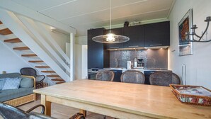 Et moderne køkken med mørke skabe, en stålkogeplade og en hængende pendel.