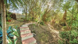 A concrete staircase leading through a garden with various plants and trees. - 2 bedroom awesome home in Badesi OT (Badesi OT)