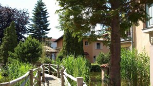 A wooden bridge over a water body, surrounded by greenery and buildings. - L-39 - Residence Laguna Whg L-39 .. (Kühlungsborn)