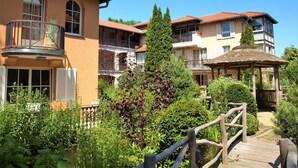 A hotel with multiple balconies, a wooden deck, and lush greenery. - L-39 - Residence Laguna Whg L-39 .. (Kühlungsborn)