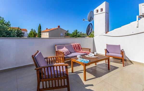An outdoor patio with wooden furniture, a white wall, and a satellite dish. - 5 bedroom lovely apartment in Medulin (Medulin)