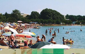 A crowded beach with people swimming and sunbathing under colorful umbrellas. - 5 bedroom lovely apartment in Medulin (Medulin)