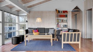 A modern living room with a sofa, a coffee table, and a bookshelf.