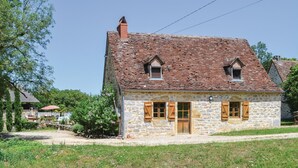 A stone house with a steeply pitched roof, two small windows, and a wooden door. - Cozy home in Padirac/Bascoul with WiFi (Padirac/Bascoul)