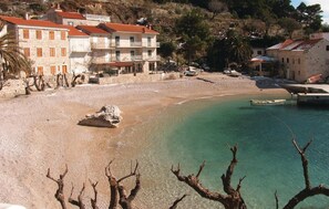 A coastal area with a sandy beach, clear turquoise water, and buildings with balconies. - Cozy home in Podobuce with house sea view (Podobuce)