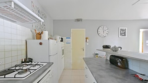 A kitchen with a gas stove, white cabinets, a refrigerator, and a microwave. - 3 bedroom nice home in Mazan (Mazan)