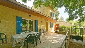 An outdoor patio with a table and chairs, a wooden pergola, and a view of a garden. - 3 bedroom nice home in Mazan (Mazan)