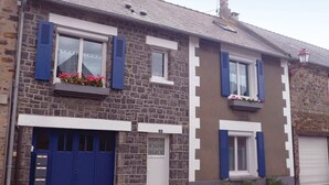A two-story stone house with blue shutters, a white door, and flower boxes on the windowsills. - Gorgeous apartment in Vildé-la-Marine (Vildé-la-Marine)