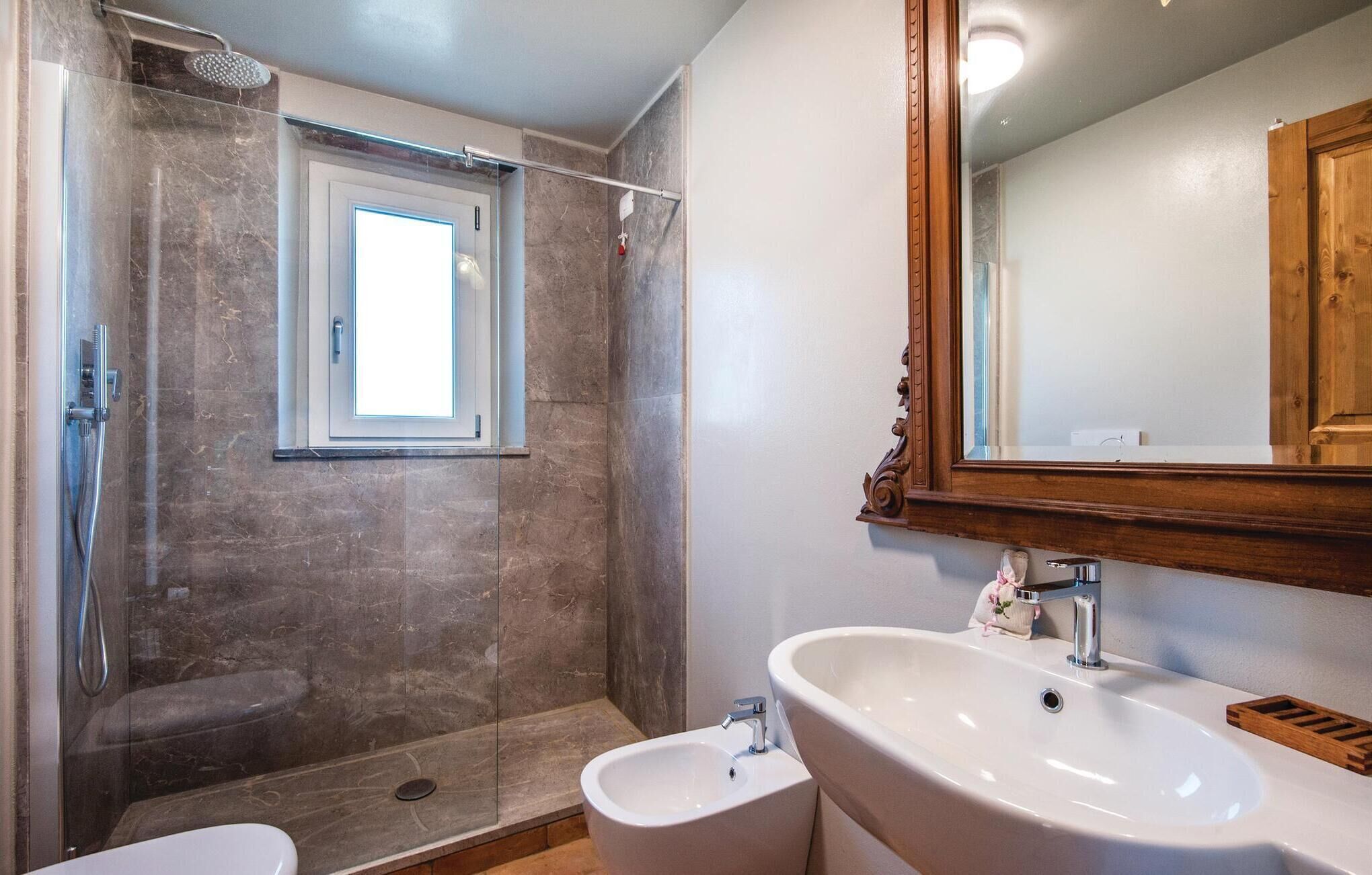 A bathroom with a shower, a sink, and a mirror.
