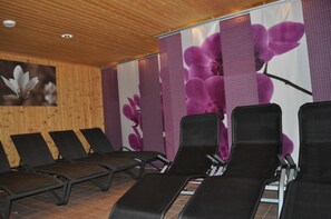 A room with wooden panel walls, a ceiling with recessed lighting, and a row of black lounge chairs. - Mathiasl Panorama Apartments - Panorama Apartment (Winkl Ossiachberg)