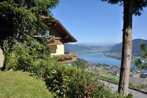 A chalet with a balcony overlooking a lake and mountains. - Mathiasl Panorama Apartments - Panorama Apartment (Winkl Ossiachberg)