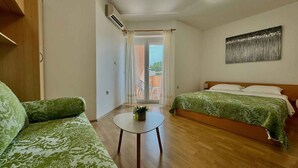 Un dormitorio con dos camas, una mesita y vistas al exterior.
