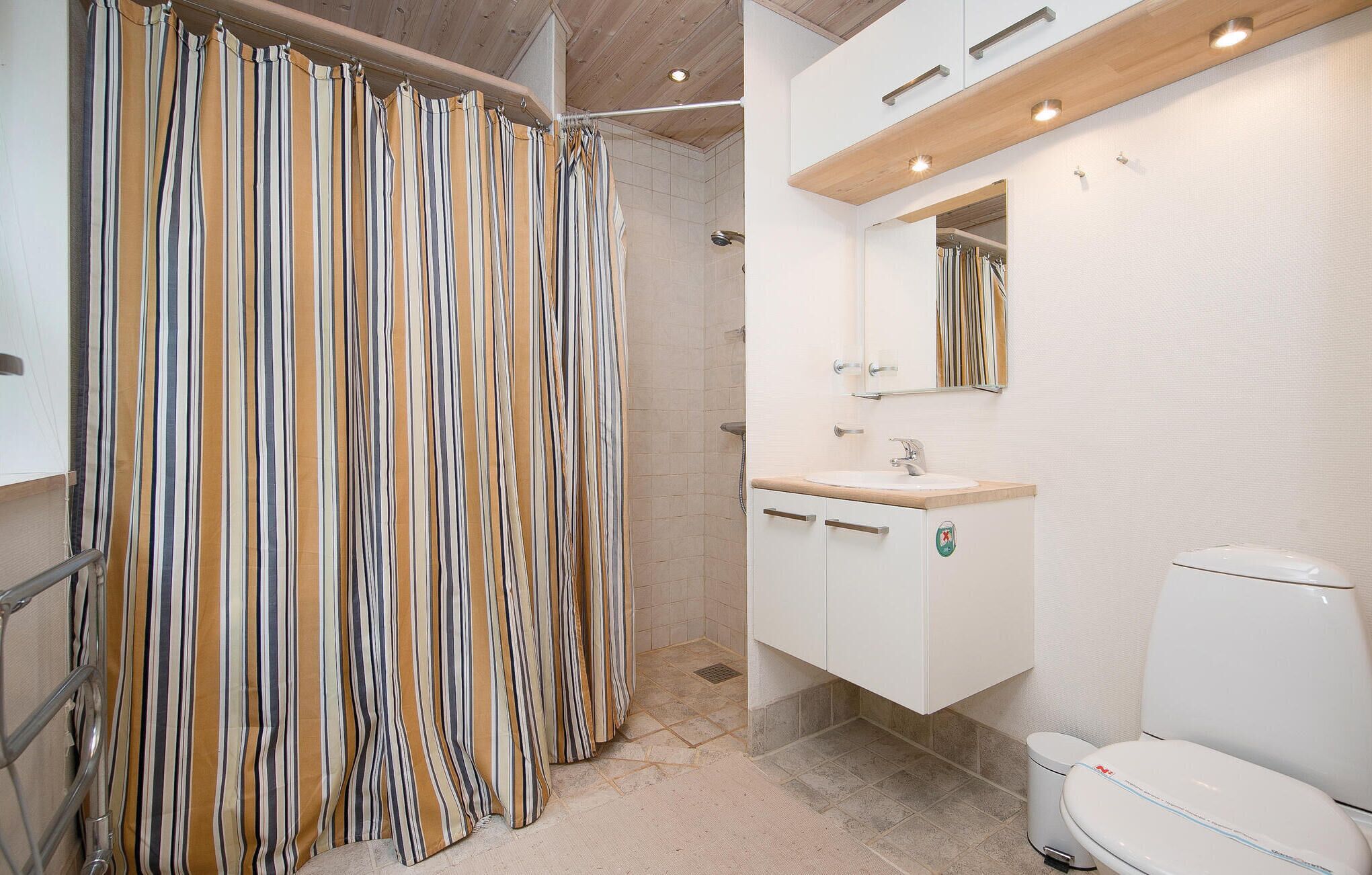 Une salle de bain moderne équipée d’une douche, d’un lavabo et de toilettes.