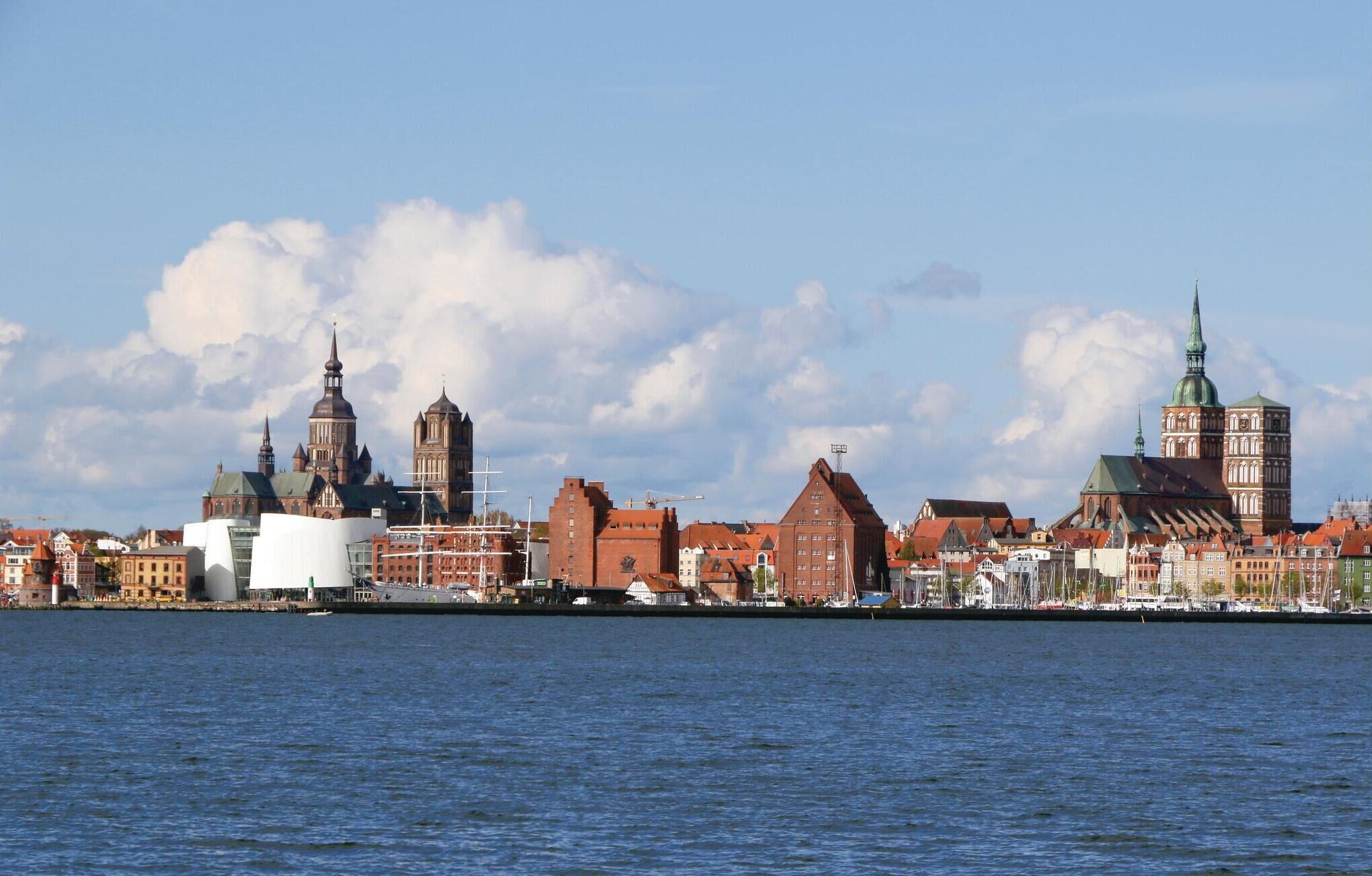 A waterfront cityscape with historic buildings and a prominent church spire.