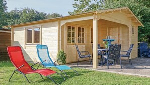 A wooden cabin with a porch, a table, and four chairs. - Ferienhaus 44 Altefähr (Altefähr/Rügen)