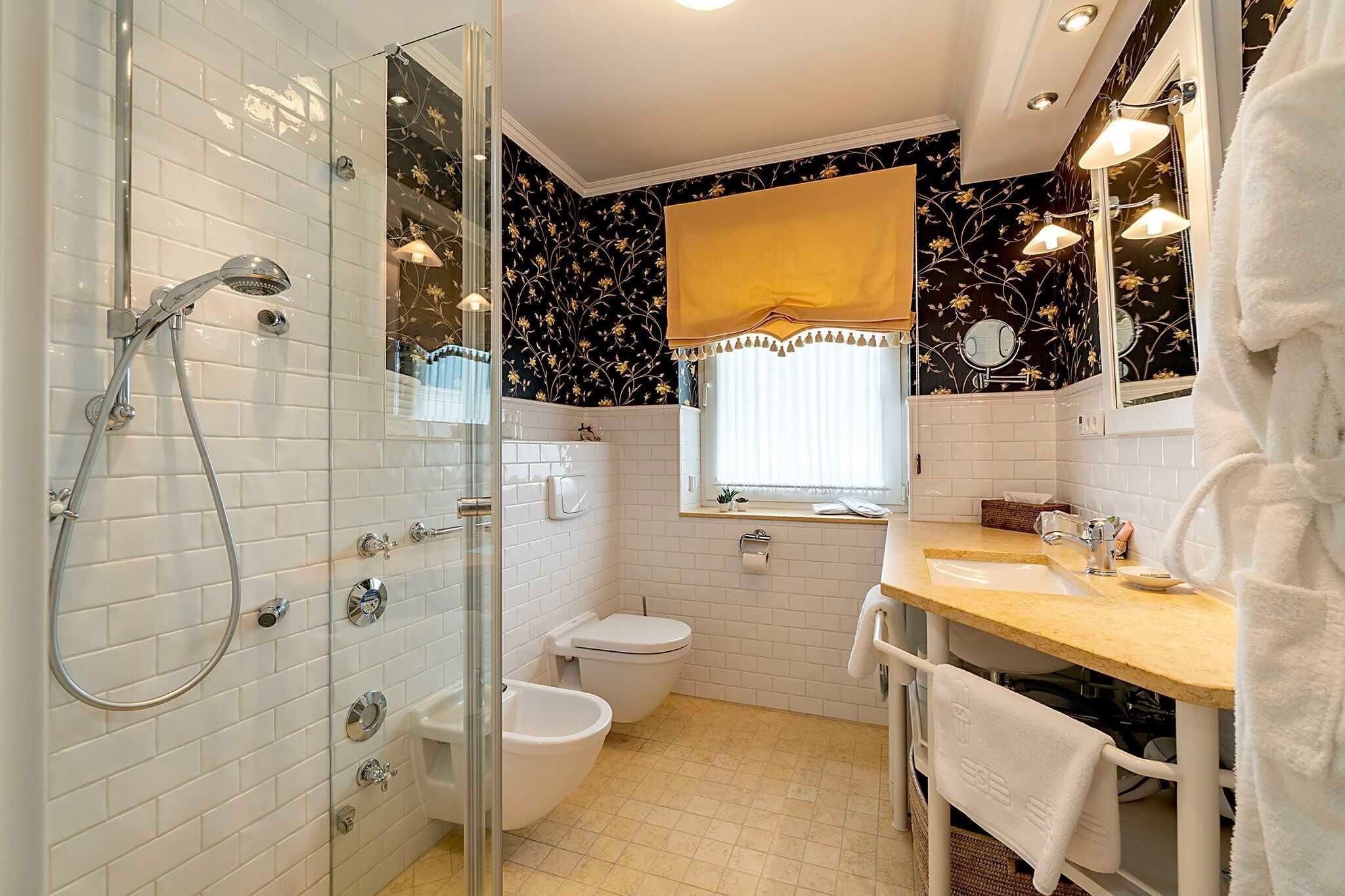Ein Badezimmer mit Duschkabine, Toilette, Waschbecken und Spiegel.