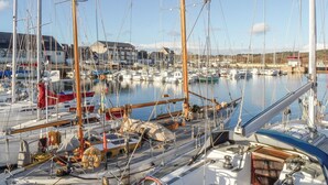 Un port de plaisance où sont amarrés de nombreux voiliers, avec leurs mâts, leur gréement et divers équipements.