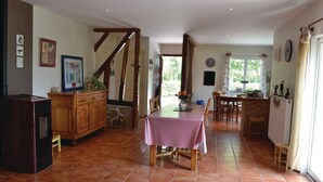 A spacious kitchen with a dining area, featuring a checkered tablecloth, wooden cabinets, and a stone fireplace. - 3 bedroom awesome home in Lottinghen (Lottinghen)