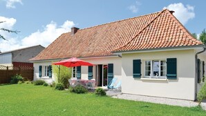 A single-story house with a tiled roof, a small porch with a red umbrella, and a well-maintained lawn. - 3 bedroom awesome home in Lottinghen (Lottinghen)