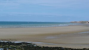 A wide sandy beach with gentle waves, a clear sky, and distant buildings. - 3 bedroom awesome home in Lottinghen (Lottinghen)